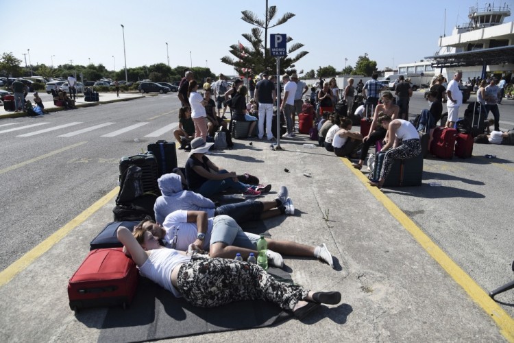 Passengers gather outside the airport after the cancelation of many flights on the Greek island of Kos on Friday, July 21, 2017. A powerful earthquake sent a building crashing down on tourists at a bar on the Greek holiday island of Kos and struck panic on the nearby shores of Turkey early Friday, killing two people and injuring some 200 people. (Nikos Christofakis/InTime News via AP)