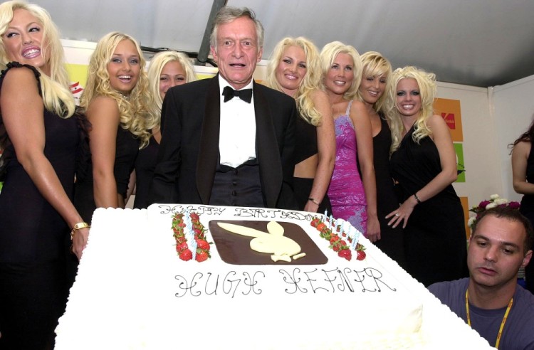 HUGH HEFNER Founder of the Playboy empire, celebrates his 75th birthday with Playboy bunnies / Playmates at the American Pavillion, Cannes Film Festival, France, 12th May 2001. half length blondes cake Ref: PL www.capitalpictures.com sales@capitalpictures.com ©Capital Pictures