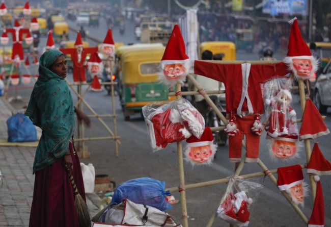 Индианка продает костюмы и маски Санта-Клауса. Фото AP PHOTO/Scanpix