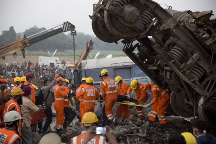 Rescuers pull out a body from the debris after 14 coaches of an overnight passenger train rolled off the track near Pukhrayan village Kanpur Dehat district, Uttar Pradesh state, India, Sunday, Nov. 20, 2016. Dozens were killed and dozens more were injured in the accident. (AP Photo/Rajesh Kumar Singh)
