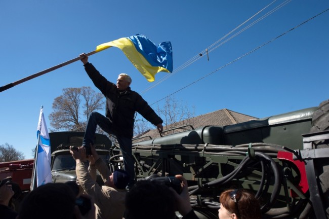 Пророссийски настроенные жители Крыма срывают украинский флаг на военной базе в Новофедоровке, март 2014 года. Фото AFP/Scanpix