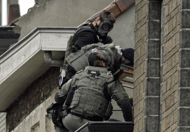 Belgium special force officers climb the outside of a house as they prep[are to enter in the Rue Delaunoy in Molenbeek-Saint-Jean of Brussels, on November 16, 2015, several days after a series of deadly attacks on the French capital Paris. During the weekend searches were carried out and multiple people were arrested in relation to the November 13 attacks in Paris which left at least 129 dead and 350 injured. Most people were killed during a concert in venue Bataclan, the other targets were a restaurant and a soccer game. The attacks have been claimed by Islamic State. AFP PHOTO/BELGA/DIRK WAEM   =BELGIUM OUT=