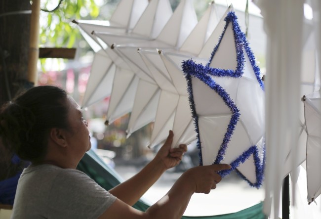 Elizabeth De Guzman, 40, arranges Christmas lanterns which they sell along a street in Manila, Philippines, Tuesday, Dec. 22, 2015. Lanterns are popular decorations in Filipino homes during the Christmas season in this largely Roman Catholic country. (AP Photo/Aaron Favila)