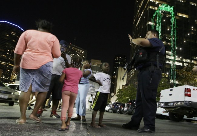 Dallas police order people away from the area after several police were shot in downtown Dallas, Thursday, July 7, 2016. (AP Photo/LM Otero)