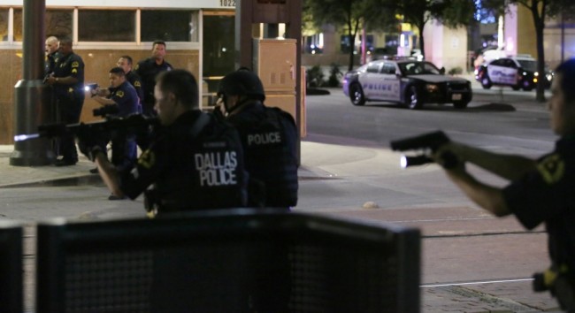 Dallas police move to detain a driver after several police officers were shot in downtown Dallas, Thursday, July 7, 2016. At least two snipers opened fire on police officers during protests Thursday night; some of the officers were killed, police said. (AP Photo/LM Otero)