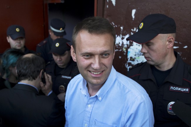 Russian opposition activist Alexei Navalny smiles as police block an entrance to the office of the society organization Open Russia, founded by Russian businessman and Amnesty International prisoner of conscience Mikhail Khodorkovsky, in Kostroma, Russia, Sunday, Sept. 13, 2015. Voters are casting ballots across Russia for local legislators and governors, in elections expected to be won by candidates loyal to President Vladimir Putin. Sundays elections are being seen as a dress rehearsal for next years vote for a national parliament, and the anti-Putin opposition was allowed to run in only one Russian region, Kostroma. (AP Photo/ Pavel Golovkin)