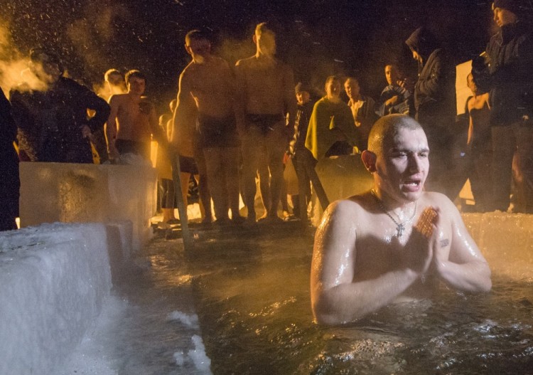 Russian Orthodox believers queue to bath in an ice-cold water of the Ob River after it was blessed by an Orthodox priest on Epiphany in Novosibirsk, about 2,800 kilometres (1,750 miles) east of Moscow, early Thursday, Jan. 19, 2017. Thousands of Russian Orthodox Church followers will plunge into icy rivers and ponds across the country to mark Epiphany, cleansing themselves with water deemed holy for the day. (AP photo/Ilnar Salakhiev)