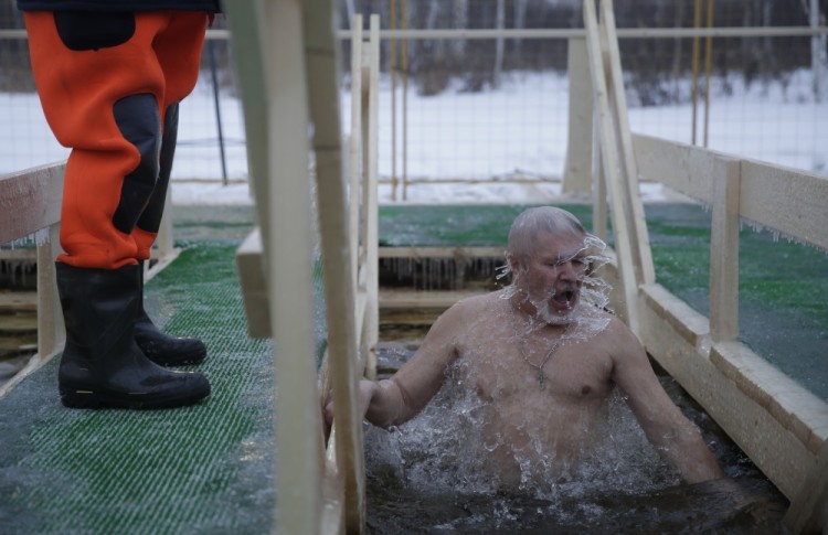 A Russian Orthodox believer swims in the icy water on Epiphany at a pond in Moscow, Thursday, Jan. 19, 2017. Thousands of Russian Orthodox Church followers will plunge into icy rivers and ponds across the country to mark Epiphany, cleansing themselves with water deemed holy for the day. (AP Photo/Pavel Golovkin)