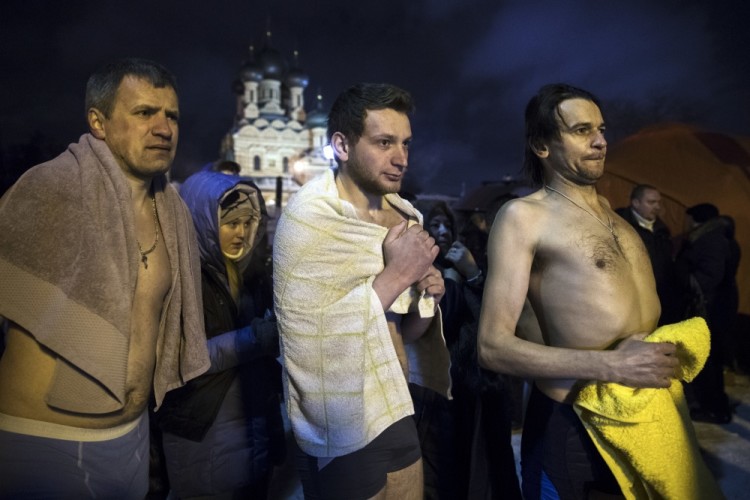 Russian people prepare to bath in the icy water to mark the Epiphany in Moscow, Russia, Wednesday, Jan. 18, 2017, with the temperature in Moscow at about -6 C (21 F). Thousands of Russian Orthodox Church followers plunged into icy rivers and ponds across the country to mark Epiphany, cleansing themselves with water deemed holy for the day.  (AP Photo/Pavel Golovkin)