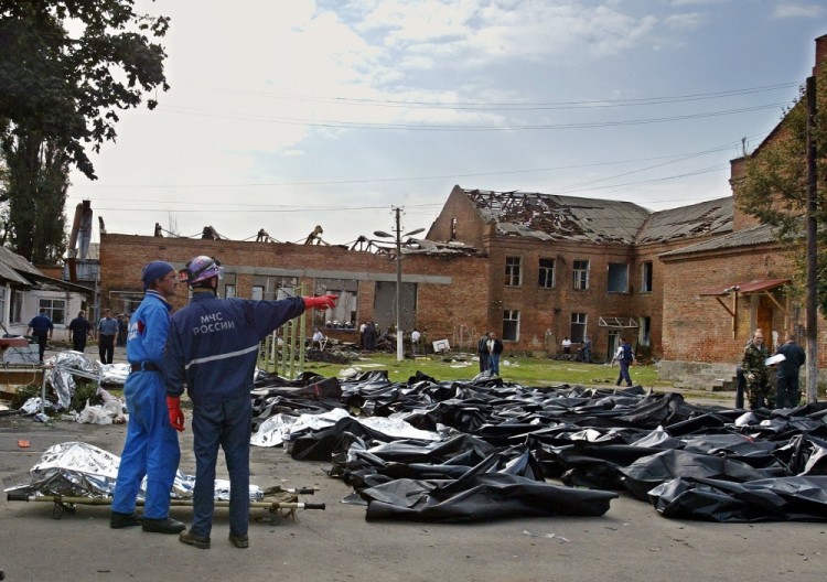 FILE In this Saturday, Sept. 4, 2004 file photo emergency workers collect corpses outside of a school in Beslan, Russia. The European Court of Human Rights said  Thursday, April 13, 2017, that Russia failed to adequately protect victims of a 2004 school siege in the city of Beslan that left more than 300 people dead. (AP Photo, File)