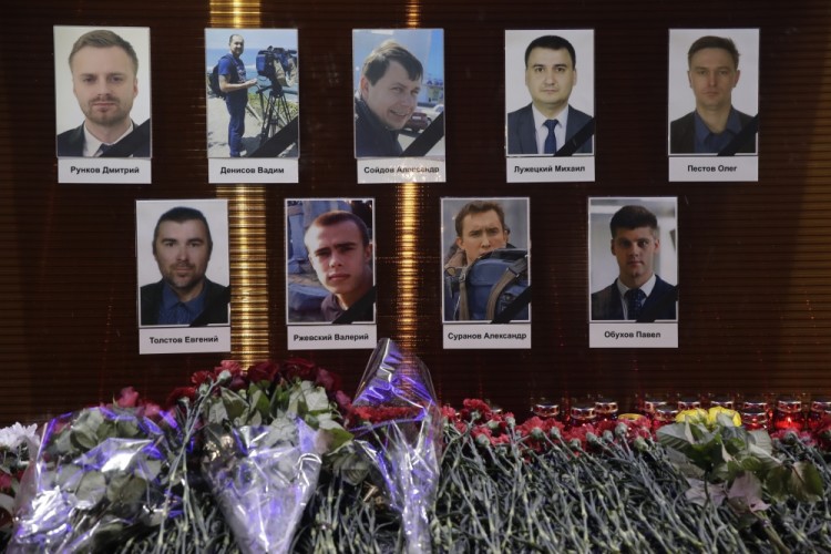 Flower tributes in front of portraits of Russian TV journalists who were aboard the crashes military plane, displayed in Moscow, Russia, Sunday, Dec. 25, 2016. A Russian plane carrying 92 people to an air base in Syria crashed Sunday into the Black Sea minutes after taking off from the city of Sochi, Russia's Defense Ministry said. (AP Photo/Pavel Golovkin)