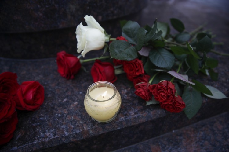 Flowers and candles are placed at the well-known military choir's building in Moscow, Russia, Sunday, Dec. 25, 2016, after a plane carrying 64 members of the Alexandrov Ensemble, crashed into the Black Sea minutes after taking off from the resort city of Sochi. The Russian plane was headed for an air base in Syria with 92 people aboard, Russia's Defense Ministry said. (AP Photo/Pavel Golovkin)