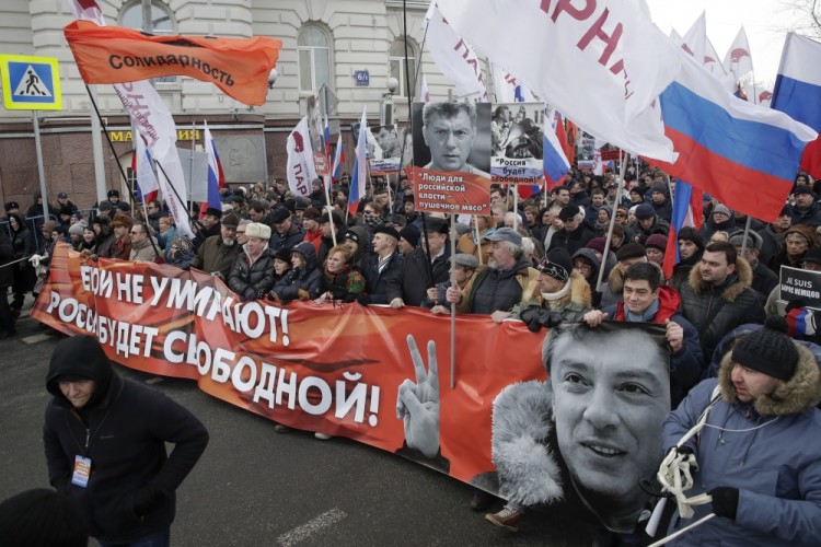 People carry a poster, reading: Heroes do not die! Russia will be free! during a march in memory of opposition leader Boris Nemtsov, in Moscow, Russia, Sunday, Feb. 26, 2017. Thousands of Russians take to the streets of downtown Moscow to mark two years since Nemtsov was gunned down outside the Kremlin. (AP Photo/Pavel Golovkin)