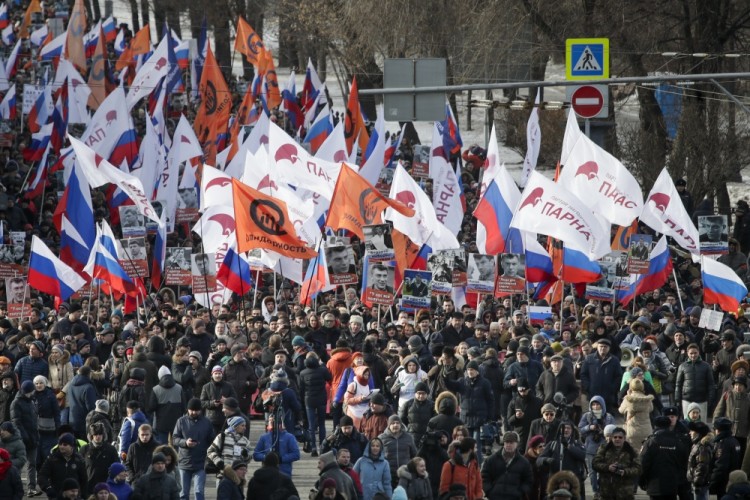 People, with flags of different opposition movements, march in memory of opposition leader Boris Nemtsov, in Moscow, Russia, Sunday, Feb. 26, 2017. Thousands of Russians take to the streets of downtown Moscow to mark two years since Nemtsov was gunned down outside the Kremlin. (AP Photo/Pavel Golovkin)