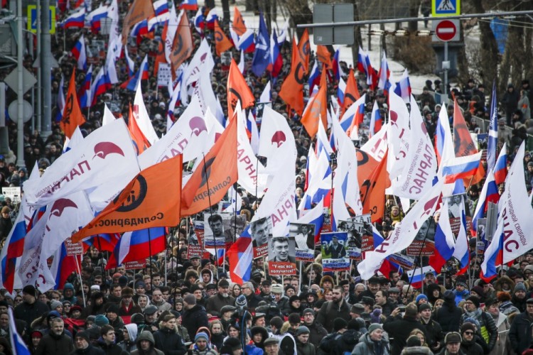 People, with flags of different opposition movements, march in memory of opposition leader Boris Nemtsov, in Moscow, Russia, Sunday, Feb. 26, 2017. Thousands of Russians take to the streets of downtown Moscow to mark two years since Nemtsov was gunned down outside the Kremlin. (AP Photo/Pavel Golovkin)