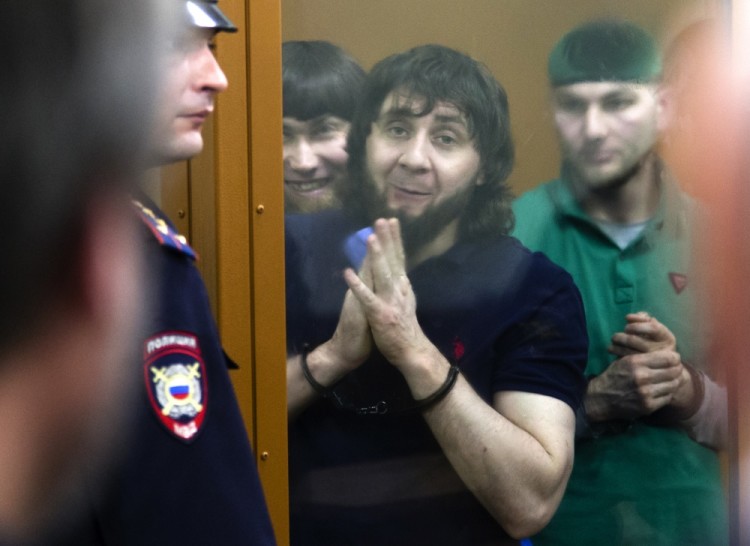 Zaur Dadayev, center left, Anzor Gubashev, center, and Shadid Gubashev, center right, listen to the sentence in a court room in Moscow, Russia, on Thursday, July 13, 2017. Zaur Dadayev, the convicted killer of Russian opposition leader Boris Nemtsov has been sentenced to 20 years in prison. Four others convicted in involvement in gunning down Nemtsov on a bridge near the Kremlin in 2015 were sentenced to terms ranging from 11 to 19 years Thursday. (AP Photo/Ivan Sekretarev)