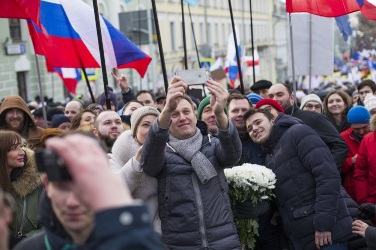 Russian opposition leader Alexei Navalny, center and his wife Yulia take a selfie during a march in memory of opposition leader Boris Nemtsov in Moscow, Russia, Sunday, Feb. 26, 2017. Thousands of Russians take to the streets of downtown Moscow to mark two years since Nemtsov was gunned down outside the Kremlin. (AP Photo/Ivan Sekretarev)