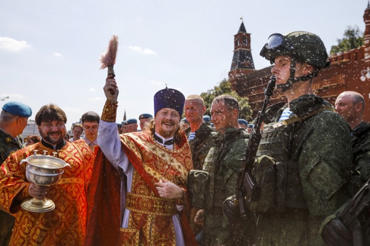 A Russian Orthodox priest blesses paratroopers during celebrations of Paratroopers Day in Red Square in Moscow, Russia, Wednesday, Aug. 2, 2017. Russian Paratroopers' Forces celebrate the 87th anniversary of the establishment of Russia's airborne forces. (AP Photo/Alexander Zemlianichenko)