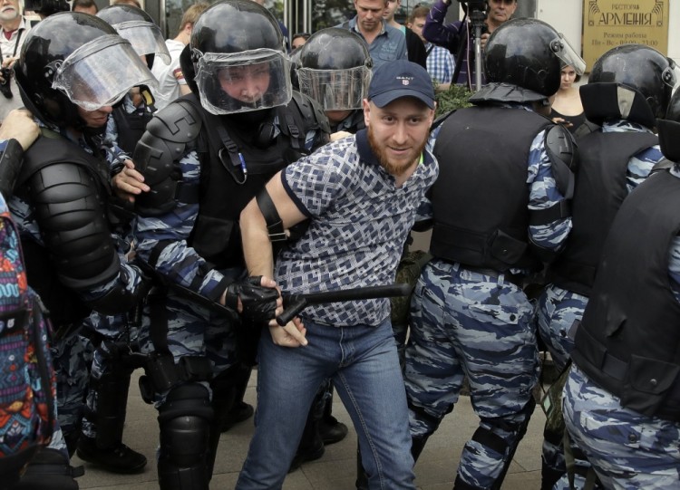 Police detain a protester during a demonstration in downtown Moscow, Russia, Monday, June 12, 2017. Russian opposition leader Alexei Navalny, aiming to repeat the nationwide protests that rattled the Kremlin three months ago, has called for a last-minute location change for a Moscow demonstration that could provoke confrontations with police. (AP Photo/Pavel Golovkin)