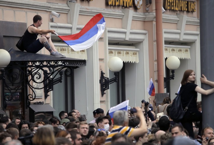 A protester waves a Russian flag during a demonstration in downtown Moscow, Russia, Monday, June 12, 2017. Russian opposition leader Alexei Navalny, aiming to repeat the nationwide protests that rattled the Kremlin three months ago, has called for a last-minute location change for a Moscow demonstration that could provoke confrontations with police. (AP Photo/Pavel Golovkin)
