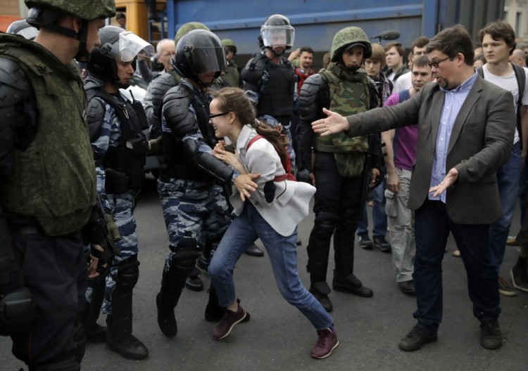 A young girl reacts after her friend was detained by police during a demonstration in downtown Moscow, Russia, Monday, June 12, 2017. Russian opposition leader Alexei Navalny, aiming to repeat the nationwide protests that rattled the Kremlin three months ago, has called for a last-minute location change for a Moscow demonstration that could provoke confrontations with police. (AP Photo/Pavel Golovkin)