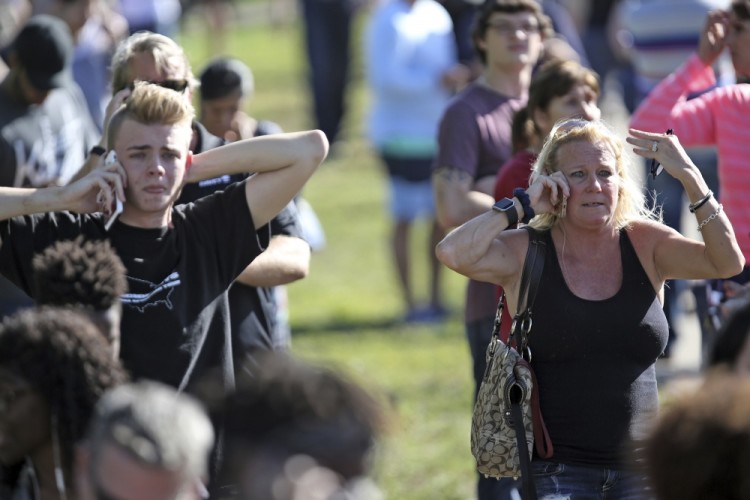 Waiting for word from students anxious family members gather at Coral Springs Drive and the Sawgrass Expressway, just south of the campus ,following a shooting at Marjory Stoneman Douglas High School in Parkland, Fla., Wednesday, Feb. 14, 2018. (Amy Beth Bennett/South Florida Sun-Sentinel via AP)