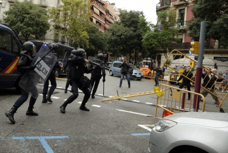 Spanish National Police clashes with pro-referendum supporters in Barcelona Sunday, Oct. 1 2017. Catalonia's planned referendum on secession is due to be held Sunday by the pro-independence Catalan government but Spain's government calls the vote illegal, since it violates the constitution, and the country's Constitutional Court has ordered it suspended. (AP Photo/Manu Fernandez)