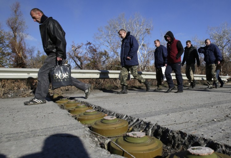 Украинские военнослужащие перешагивают через противотанковые мины в ходе их обмена на пленных из непризнанных республик. Фото: AFP/Scanpix/Leta