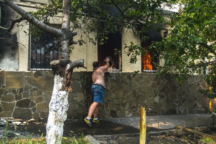 ROSTOV-ON-DON, RUSSIA - AUGUST 21, 2017: A local resident fights the fire in a residential area in the city centre. Yevgeny Dubrovsky/TASS