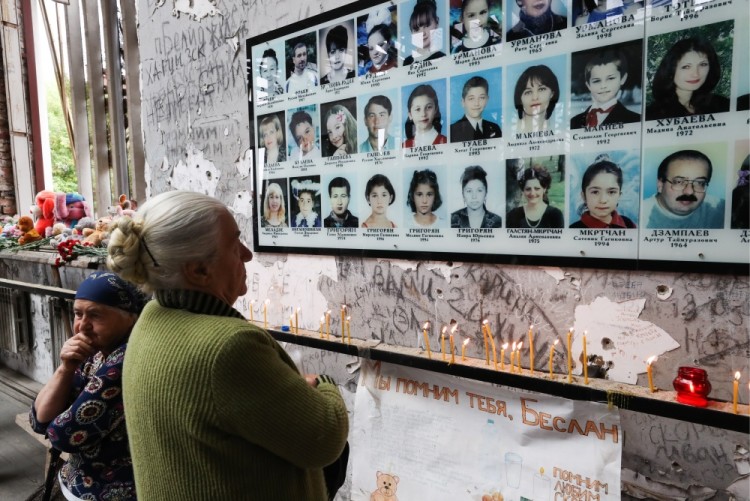 BESLAN, RUSSIA - SEPTEMBER 1, 2017: A woman looks at photos of the victims of the 2004 Beslan school siege seen during a memorial event in the gym of School No 1. On September 1, 2004, a group of Chechen militants took more than 1,200 people hostage; the hostage crisis lasted for 3 days, leaving 334 people dead, including 186 children. Sergei Savostyanov/TASS