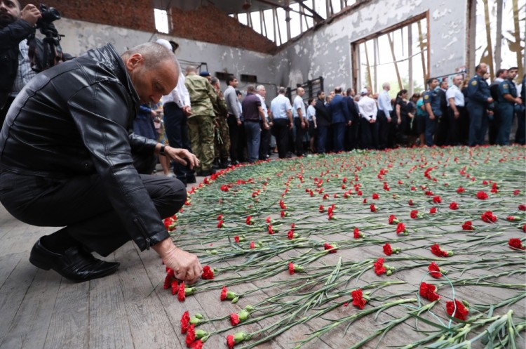 BESLAN, RUSSIA - SEPTEMBER 1, 2017: People lay red carnations on the floor during an event in memory of the victims of the 2004 Beslan school siege in the gym of School No 1. On September 1, 2004, a group of Chechen militants took more than 1,200 people hostage; the hostage crisis lasted for 3 days, leaving 334 people dead, including 186 children. Sergei Savostyanov/TASS
