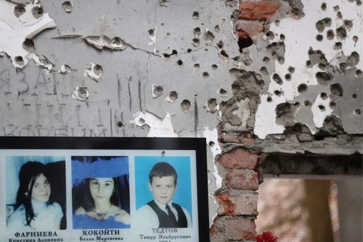 BESLAN, RUSSIA - SEPTEMBER 1, 2017: Bullet holes on a wall and photos of the victims of the 2004 Beslan school siege seen during a memorial event in the gym of School No 1. On September 1, 2004, a group of Chechen militants took more than 1,200 people hostage; the hostage crisis lasted for 3 days, leaving 334 people dead, including 186 children. Sergei Savostyanov/TASS
