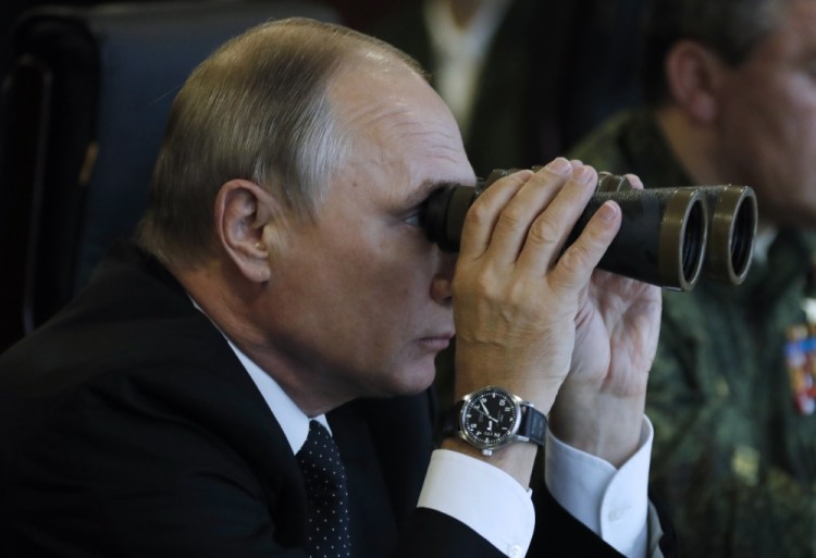 LENINGRAD REGION, RUSSIA - SEPTEMBER 18, 2017: Russia's President Vladimir Putin looks through field glasses as he watches Zapad 2017, joint Russian and Belarusian military exercises, at Luzhsky training ground. Mikhail Metzel/TASS