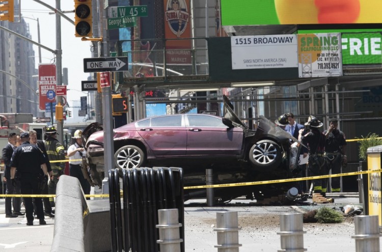 A car rests on a security barrier in New York's Times Square after driving through a crowd of pedestrians, injuring at least a dozen people, Thursday, May 18, 2017.  (AP Photo/Mary Altaffer)