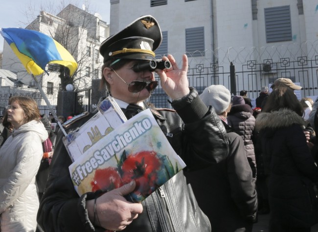 Ukrainians attend a rally to support Ukrainian pilot Nadezhda Savchenko, outside the Russian Embassy in Kiev, Ukraine, Tuesday, March 8, 2016. About 1,000 people rallied at the Russian Embassy to demand that Russia release Ukrainian pilot Nadezhda Savchenko. Savchenko was captured in June 2014 while fighting with a Ukrainian volunteer battalion against Russia-backed rebels in eastern Ukraine. She is now on trial in Russia, accused of acting as a spotter who called in coordinates for a mortar attack that killed two Russian journalists and several other civilians. (AP Photo/Efrem Lukatsky)
