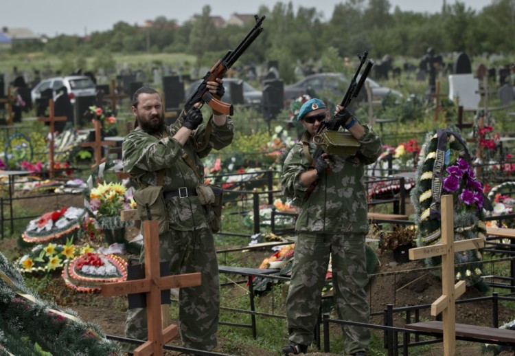 Ополченцы производят салют в честь погибшего сослуживца. Фото: AP / Scanpix