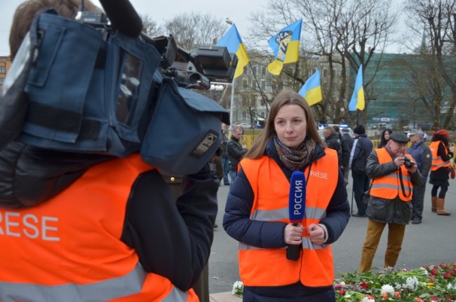 Съемочная группа телеканала «Россия» снимает людей с украинскими флагами перед памятником Свободы в Риге после марша легионеров. Фото Антона Лысенкова «Спектр».